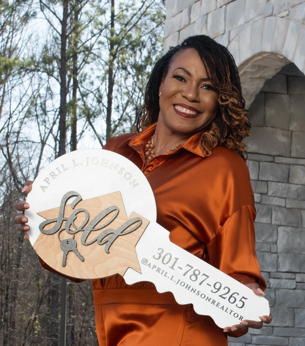 April Johnson holding a sold key sign